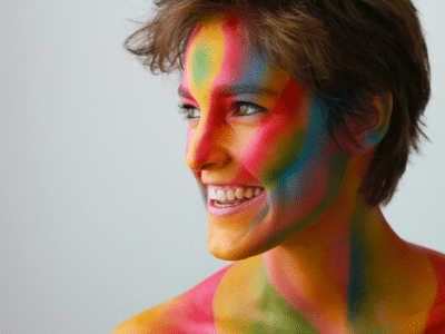 Happy healthy woman smiling colourful paint on face